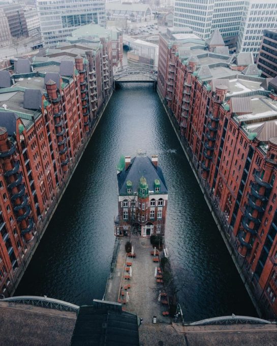 The Wasserschloss in the middle of a canal between the row of historic warehouses in Speicherstadt